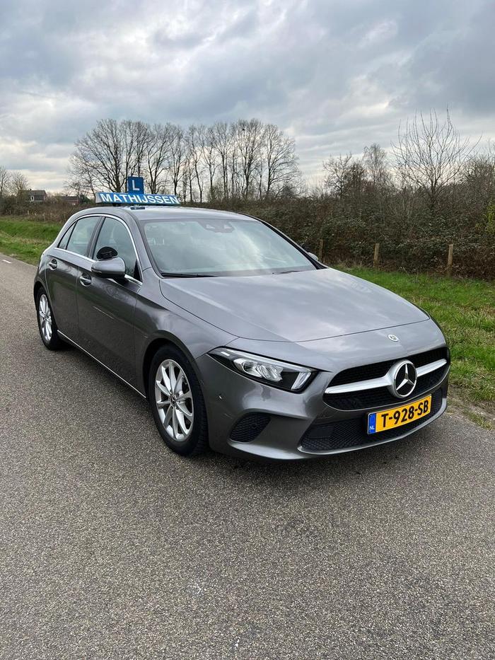 De Mercedes A-klasse lesauto van Autorijschool Mathijssen met het daklichtbord Mathijssen